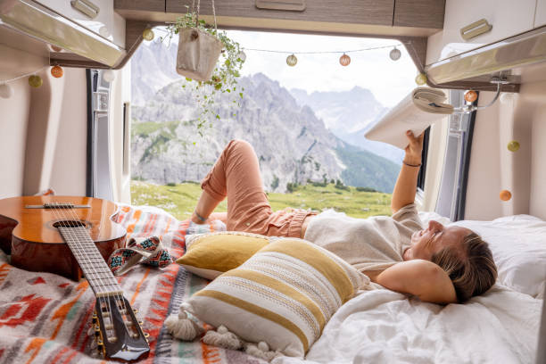 istock Lounging in Camper Van with Book and Guitar, Mountain View 2169395952