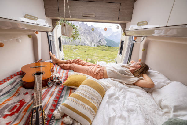 istock Woman Relaxing in Camper Van Bed Surrounded by Nature 2169396031