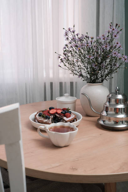 istock A Beautiful and Delicious Breakfast Setting Featuring Fresh cake with Fruits Accompanied by Flowers in ceramic vase. 2169396835