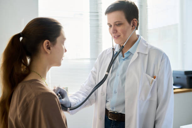 istock Smiling Doctor Using Stethoscope Checking Patient's Heartbeat 2169401895