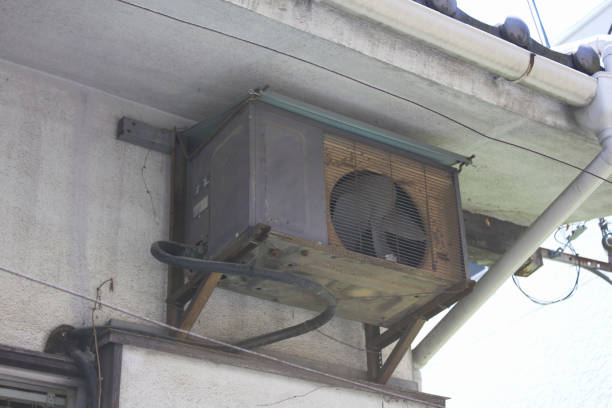 The outdoor unit of an old air conditioner has rusted because it has been installed outside for a long time.