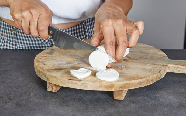 istock Hands Cutting Various Ingredients on Wooden Boards 2169406011