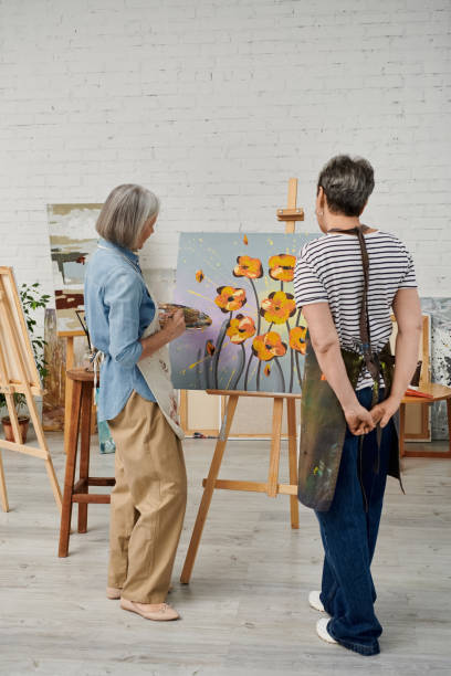 istock Mature lesbian couple joyfully making art in a cozy studio at sunset 2169406482