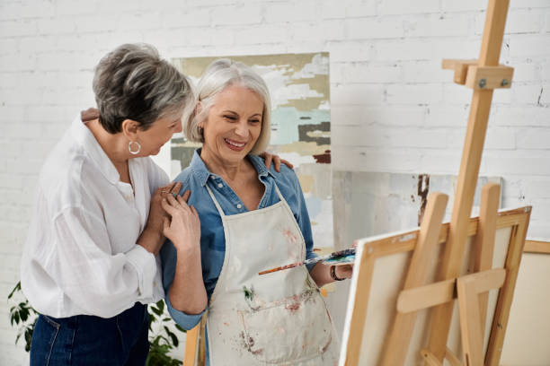 istock A mature lesbian couple joyfully painting together in a bright, creative studio space 2169406723