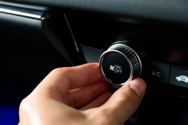 istock Close up hand turning the button to automatically adjust the air conditioning temperature in a modern car luxury interior 2024. Function control buttons in modern car. 2169406951