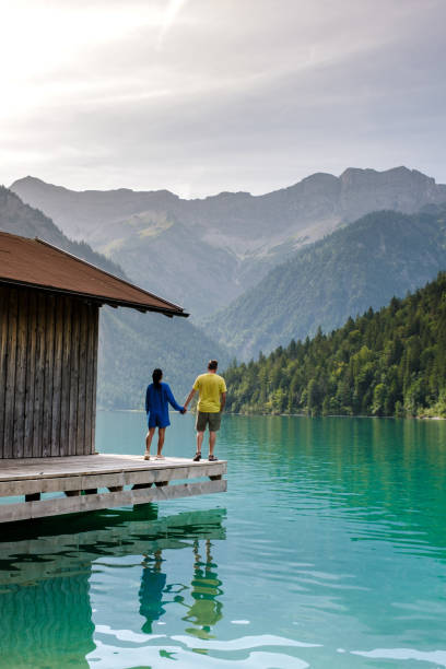 istock Idyllic lakeside stroll at Plansee, Austria, with mountains reflecting in the tranquil waters 2169411119