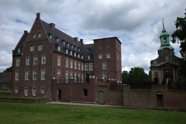 Wesel, Germany - July 8 2024 In the middle of the natural landscape of the Lower Rhine lies castle Dierfordt with a rococo church.It was first build in 1432 and rebuild in 1929 after a fire