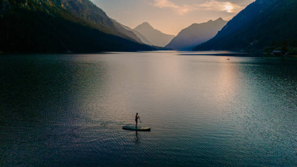 A tranquil evening paddleboarding adventure at Plansee Lake in Austria surrounded by mountains