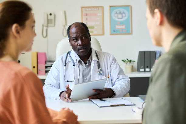 istock Discussing Healthcare Options with Doctor Using Tablet 2169413602