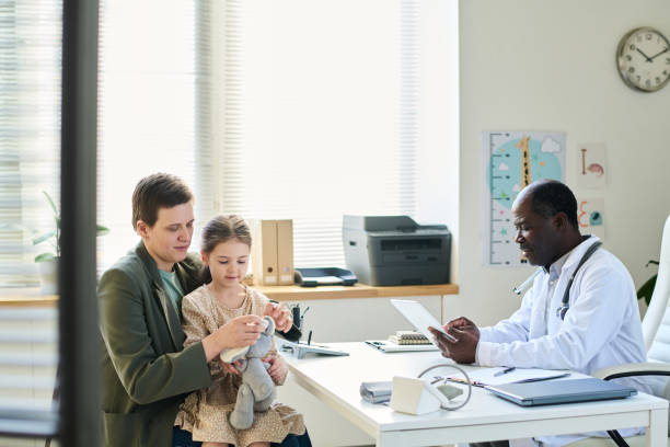 istock Consulting with Pediatrician During Office Visit 2169413620