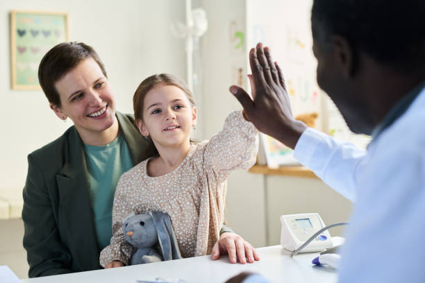 istock Smiling Nurse Celebrating Young Patient with High-Five 2169413621