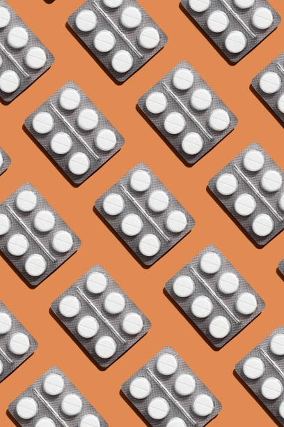istock Pattern of blister pack with six round white tablets on orange background, creating a visually striking geometric layout. Creative pills concept 2169416611