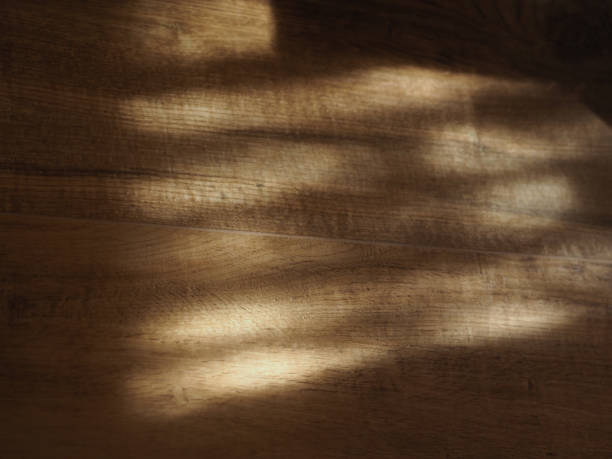 Sunlight Through Blinds: A Horizontal Close-Up of Sunspot Patterns on a Beige Floor in an Italian Home