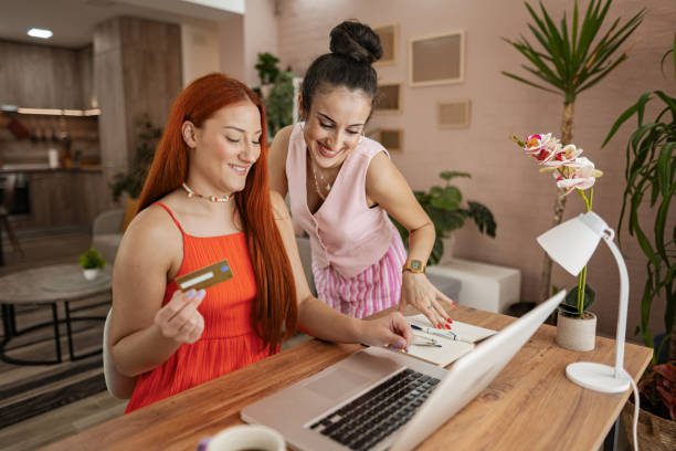 istock Two friends enjoy a productive afternoon together, exploring online shopping while sipping coffee in a cozy modern workspace 2169418843