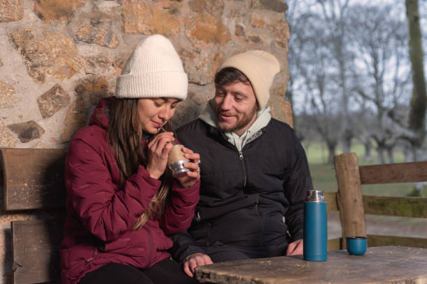 istock couple of mountaineers drinking mate while resting 2169420327