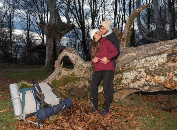 mountain couple hugging leaning on a log