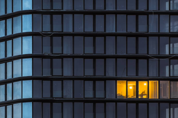 Windows of a new office building during the evening work of a workman
