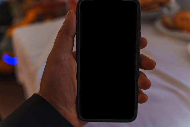 istock A man's hand with a smartphone and a black blank screen. 2169426258