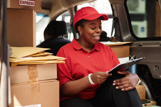 istock Smiling Worker in Delivery Van with Packages 2169432669