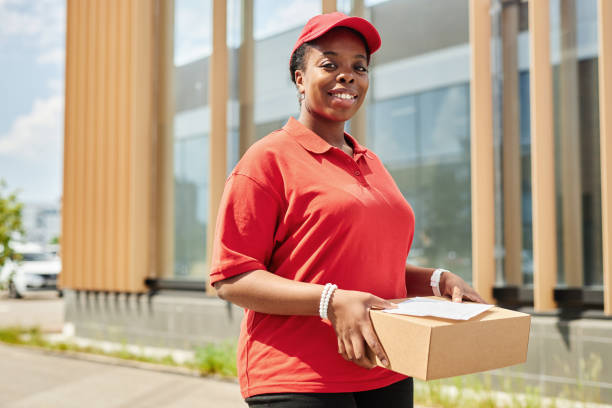 istock Smiling Delivery Worker Holding Package in Urban Setting 2169432711