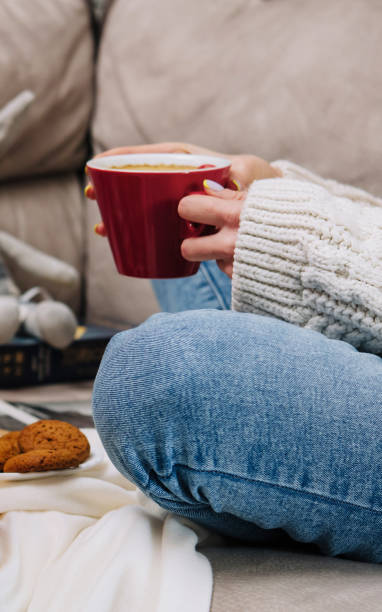 istock Woman relaxing on sofa with coffee and cookies 2169433301