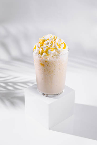 istock Caramel milkshake with whipped cream standing on white cube 2169433828