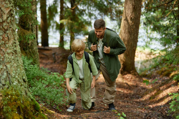 istock Father and Son Exploring Forest Together Wearing Backpacks 2169434171