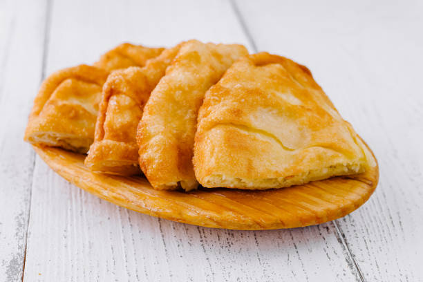 Delicious langos, a deep-fried dough, served on a wooden plate, a popular street food in hungary