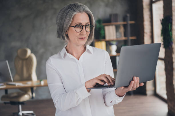 istock Portrait of smart experienced recruiter lady  hold use wireless netbook write message networking business center indoors 2169436253