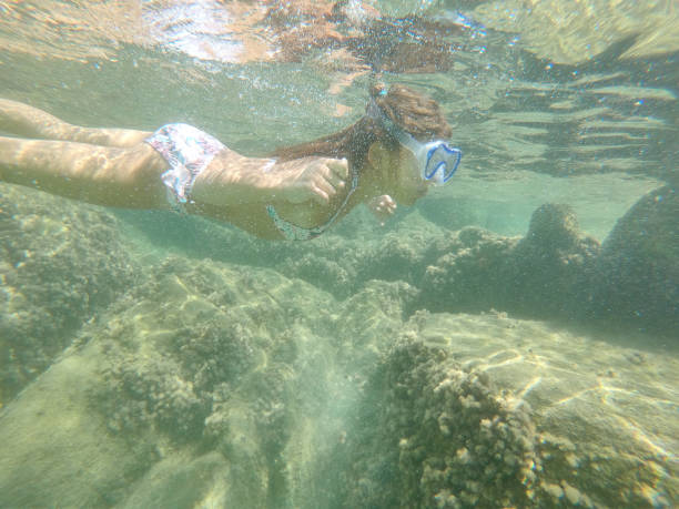 istock Young caucasian girl moving down underwater 2169437380
