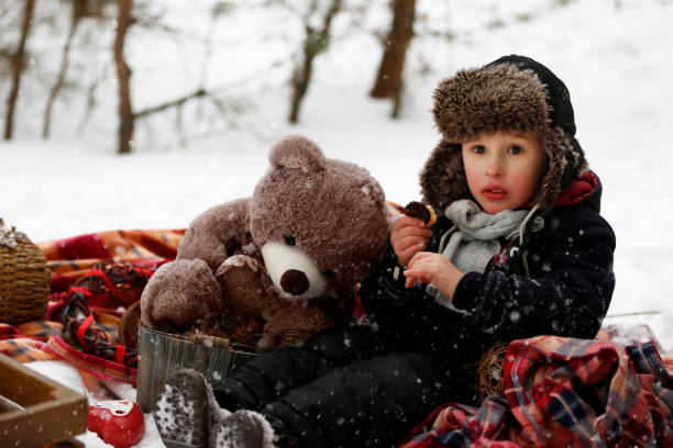 istock A little boy at a winter picnic holds a teddy bear. 2169438672