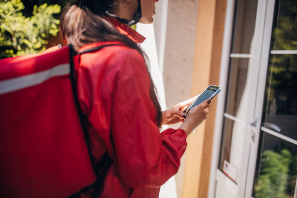 istock Delivery person using phone to confirm delivery address 2169440552