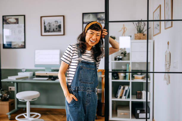 istock Smiling beautiful casually clothed woman posing for camera while staning at home office 2169442585