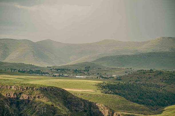 A picturesque view of Semonkong village during a rainy day in Lesotho. The mist-covered mountains and wet rooftops add a serene and atmospheric touch to this remote village, nestled in the heart of the Maloti Mountains. The lush green landscape, refreshed by the rain, highlights the natural beauty and tranquility of rural life in Lesotho. Perfect for capturing the essence of traditional village life, nature photography, and promoting Lesotho as a destination for eco-tourism and cultural exploration.