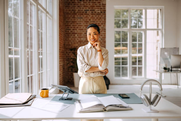 istock Smiling beautiful businesswoman posing while working at modern office 2169444533