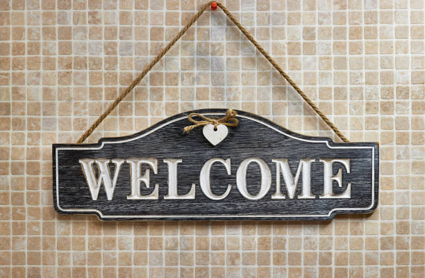 handmade wooden welcome hanging on tiles wall