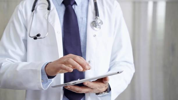 istock Doctor man wearing lab coat and stethoscope using tablet computer in hospital. Medicine and science 2169448528