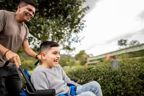 Father and son with physical disability walking on a public park