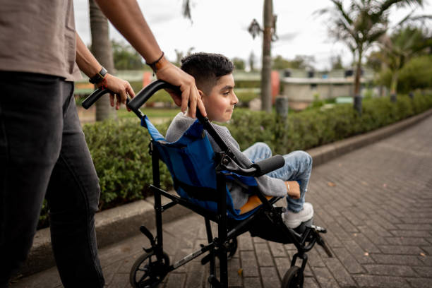Father and son with physical disability walking on a public park