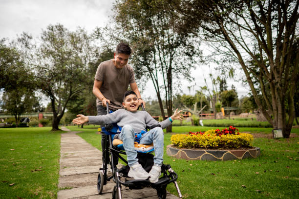 istock Father and son with physical disability walking and playing on a public park 2169448963