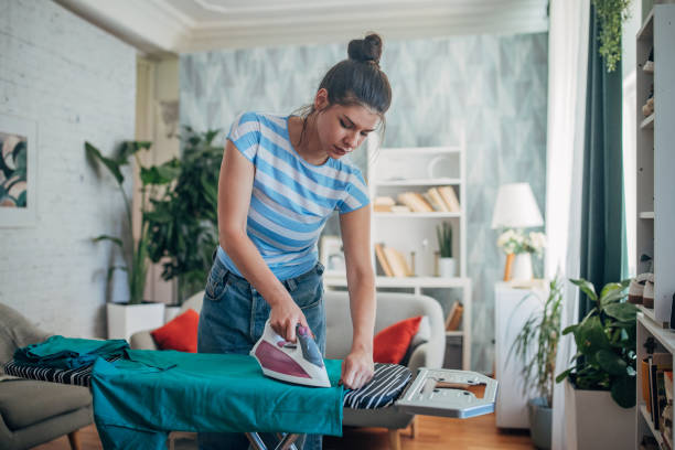 istock Woman ironing a green shirt in a comfortable home setting. 2169449013