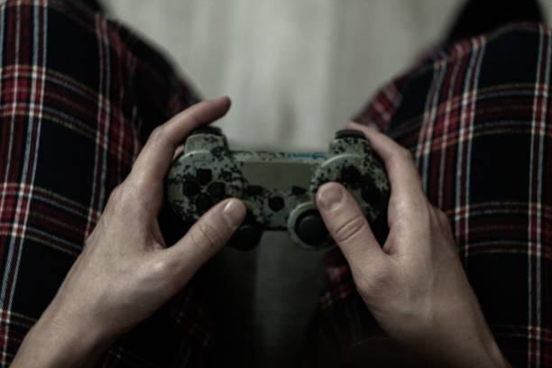 Joystick in hand: a person spends time playing games, a focused look, a relaxed position.