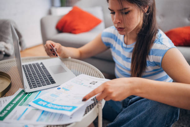 istock Woman pointing at document while holding a credit card. 2169449897