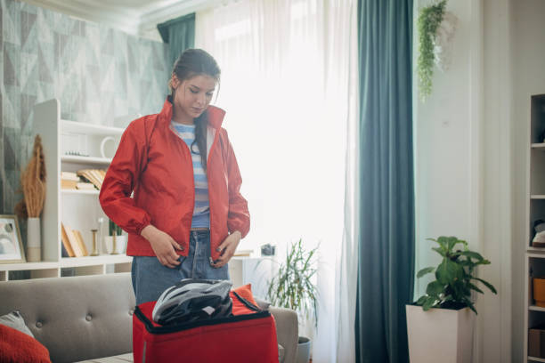 istock Woman preparing for travel while packing helmet in bag 2169449975