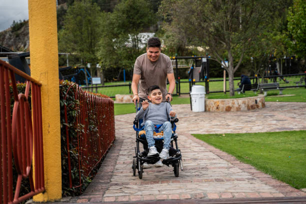 istock Father and son with physical disability walking on a public park 2169450003