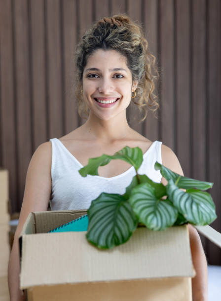 istock Happy woman holding a box while moving house 2169450083