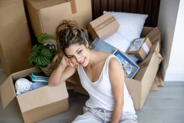 istock Woman day dreaming while packing in boxes after moving house 2169450091