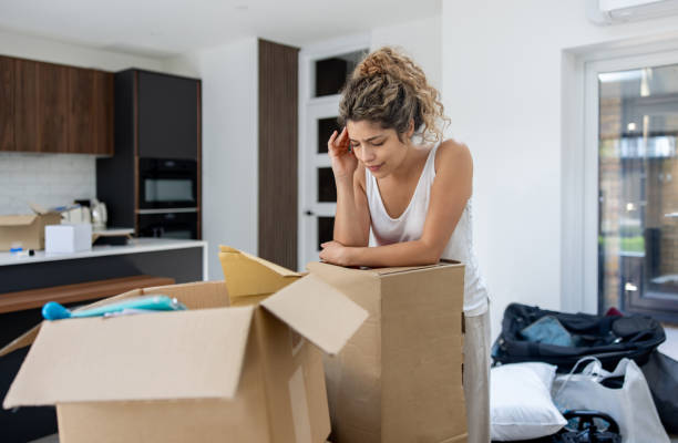 istock Stressed woman moving house and struggling with a headache while packing 2169450125