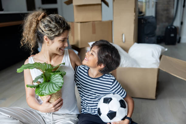 istock Happy mother and son unpacking while moving house and smiling 2169450221