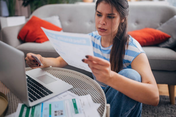 istock Woman reviewing documents at table with laptop open. 2169450439